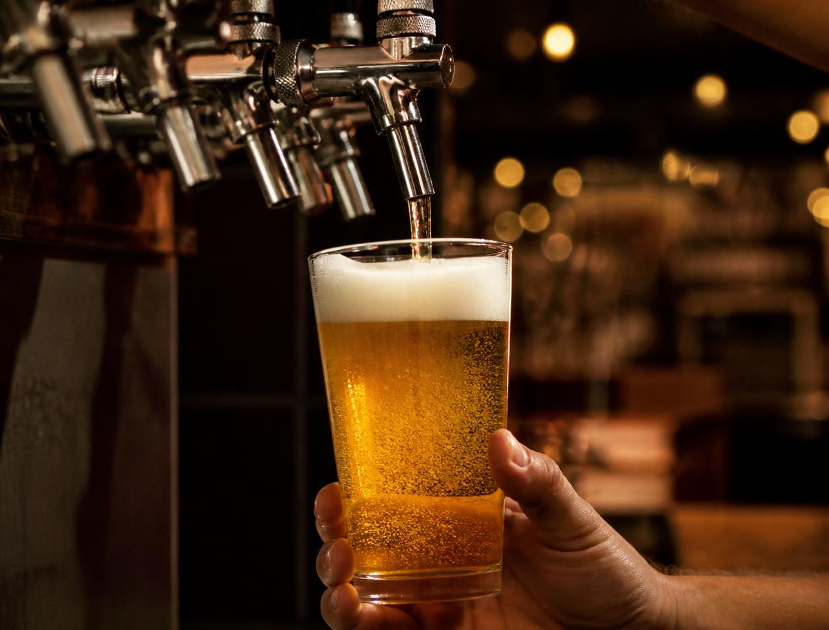 Golden beer being poured from a tap into a glass